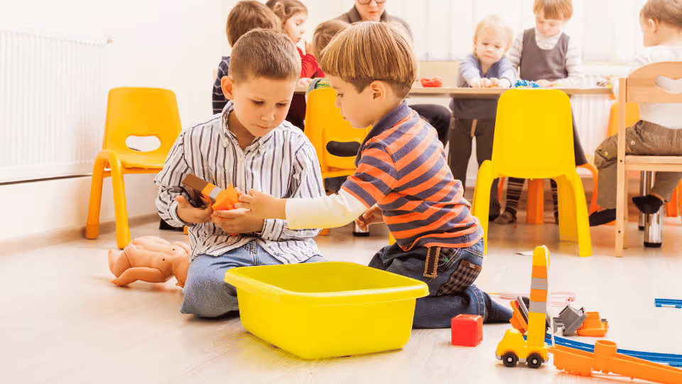 Children engaging in group play with various toys in a vibrant classroom setting, fostering collaboration and creativity.
