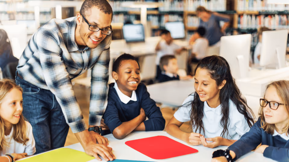 A teacher assists students in a library, demonstrating effective strategies for engaging ADHD learners in their studies