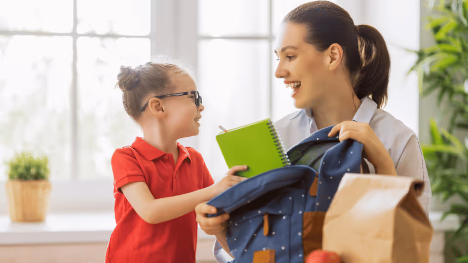 A woman and child hold a backpack and notebook, symbolizing preparation for a first treatment session.