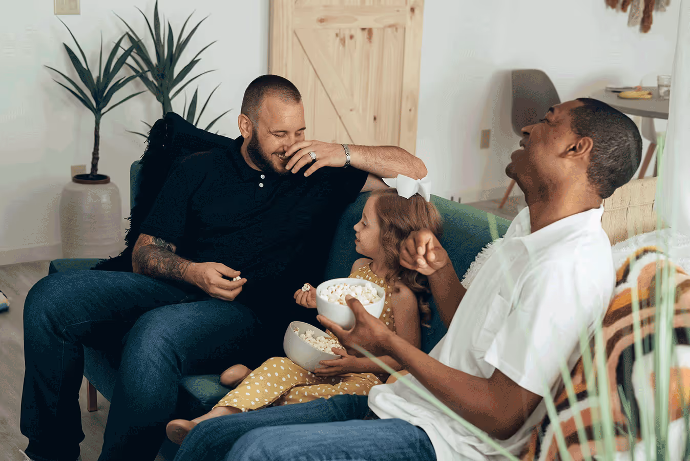 A family sits on a couch, enjoying popcorn together as part of a feeding therapy session focused on different textures.