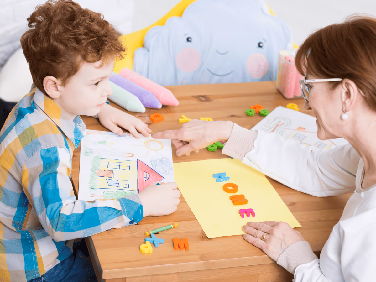 A woman supports a child while promoting skill development in an occupational therapy environment.