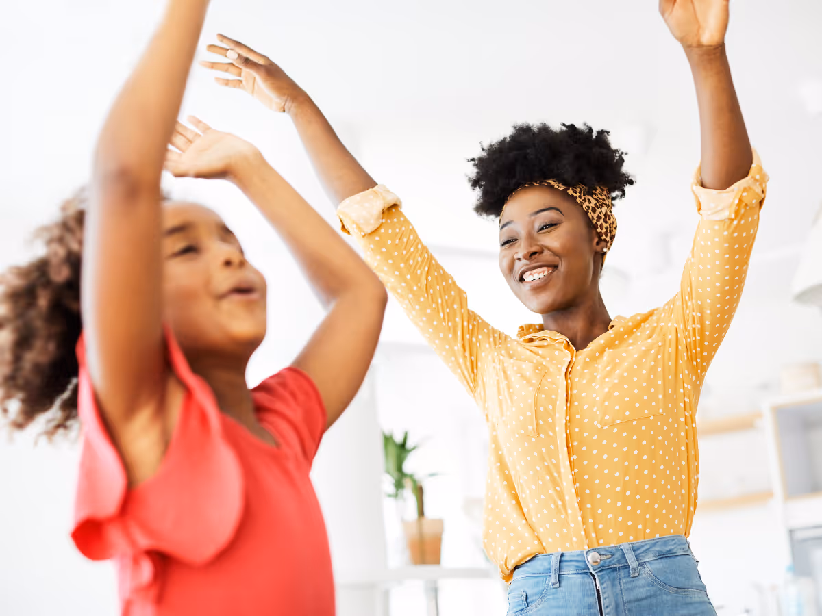 A therapist and a girl dance together, using music as part of their occupational therapy session.