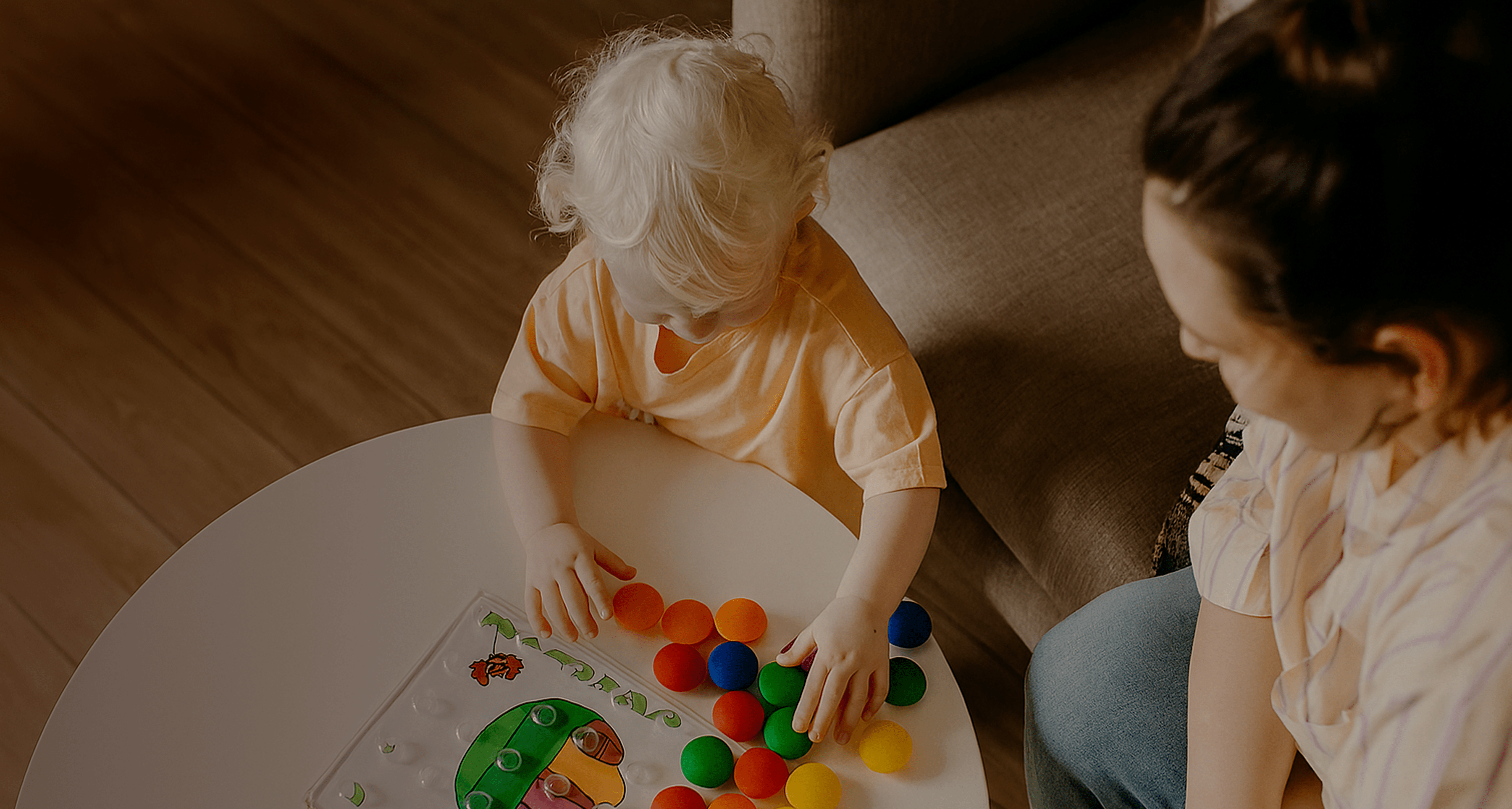 A parent practicing a play-based activity with her young child at home