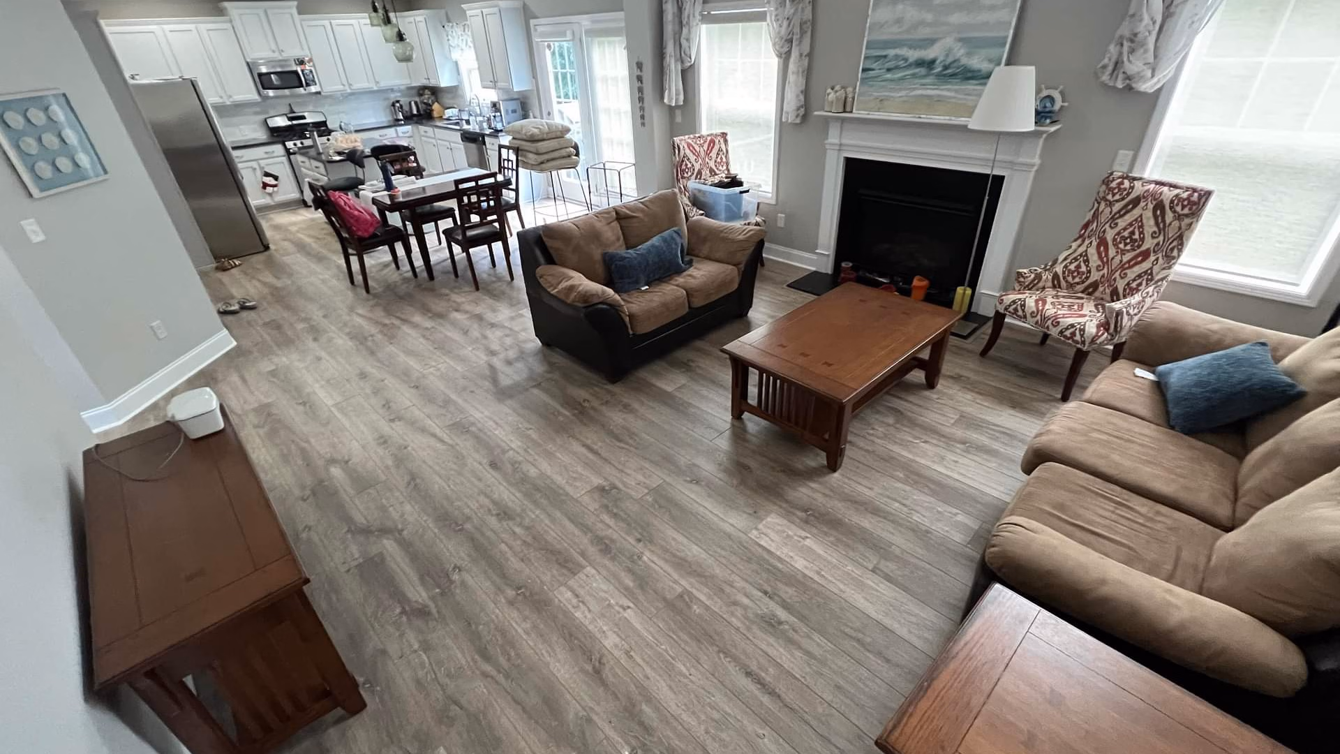 luxury vinyl flooring installed in a living room area that connects to kitchen and dining room