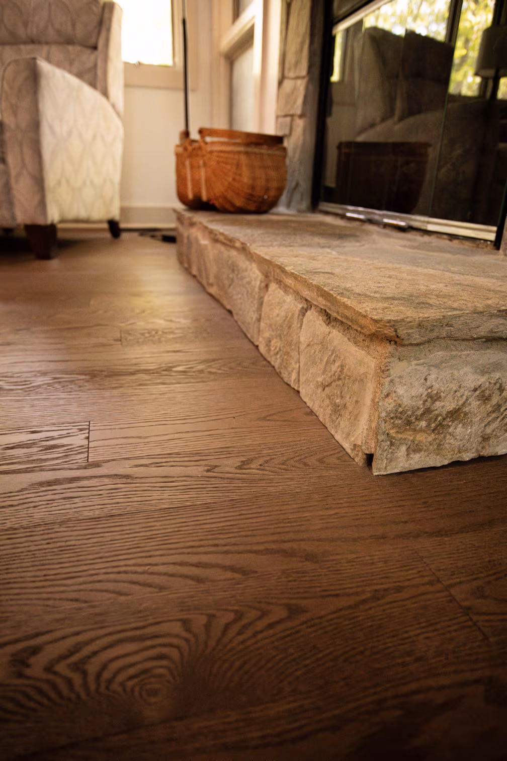 luxury hardwood flooring installed around a stone fireplace