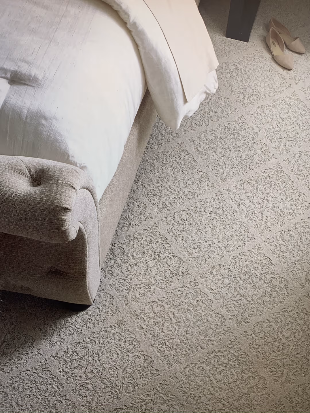 closeup of luxury grey carpet around a bed