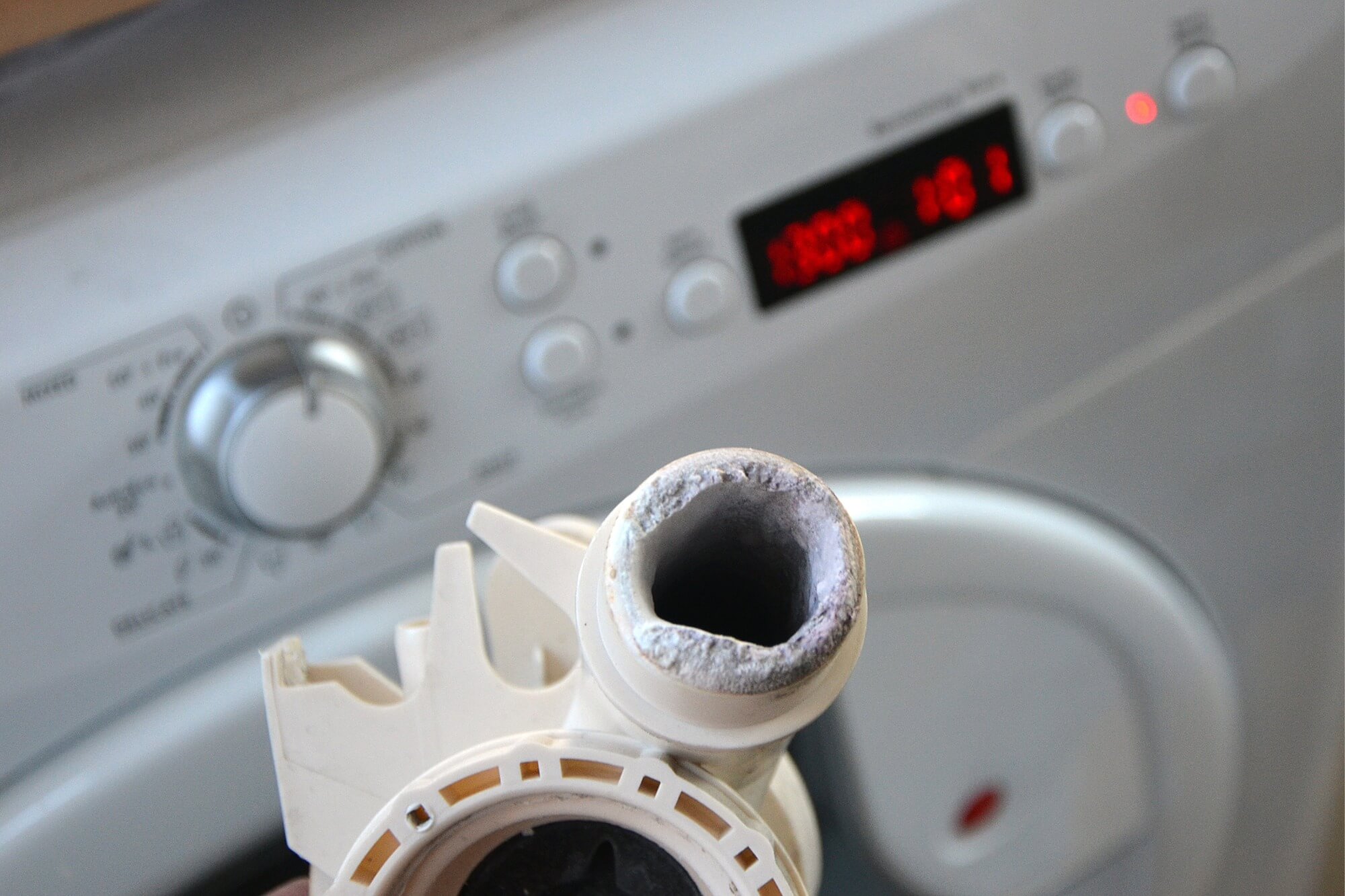 Washing machine pump clogged with limescale, highlighting maintenance issues and appliance care.