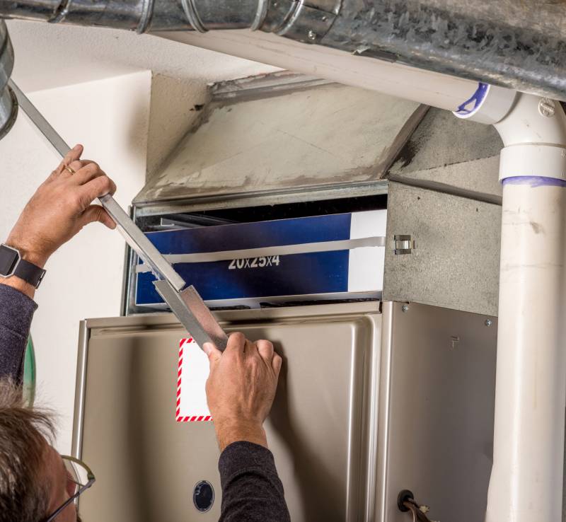 Man fixing furnace in Albuquerque home.