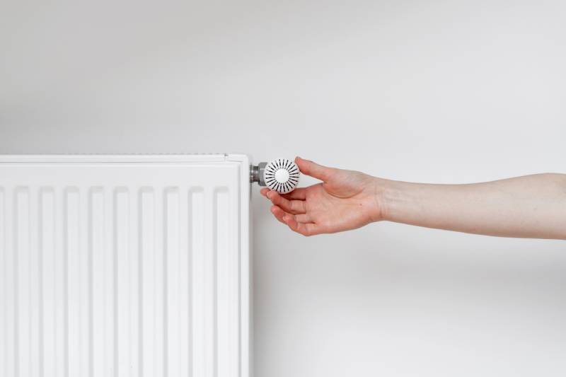Hand adjusting radiator thermostat.