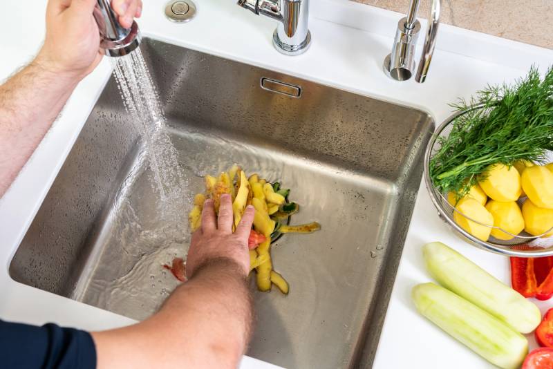 Washing vegetables in a kitchen sink.