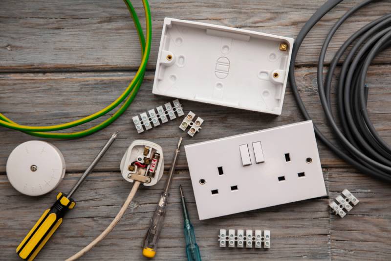 Electrical tools, wires, and outlets on wood surface
