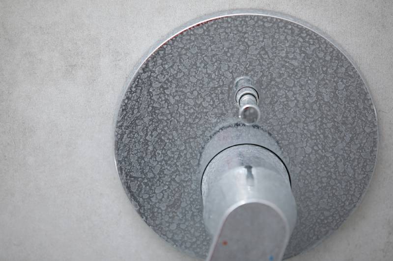Close-up of calcium buildup on metal faucet.