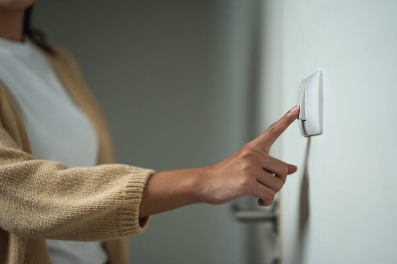 Person turning off a light switch
