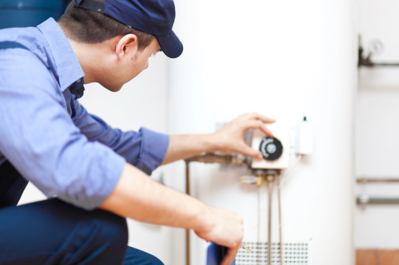 Plumber inspecting a water heater.
