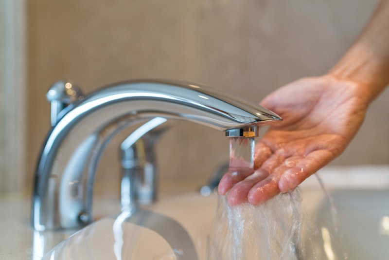 Hand under running faucet