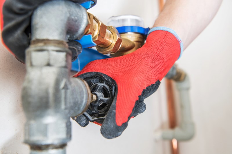 Person fixing plumbing pipes