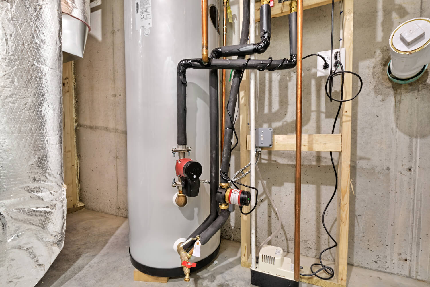 Water heater with pipes and wiring in basement.