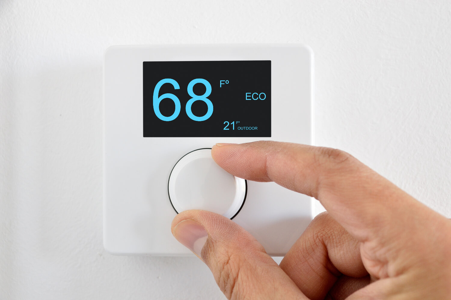 Hand adjusting digital thermostat to 68°F.