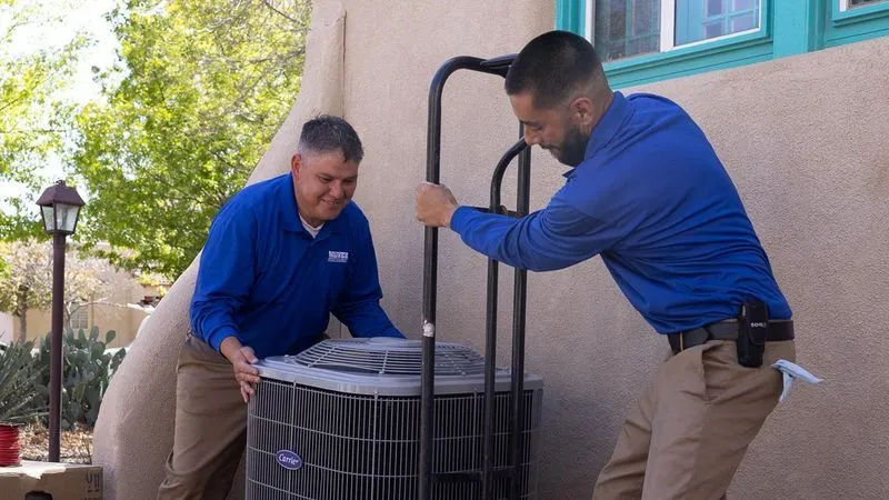 Two technicians installing an AC unit.