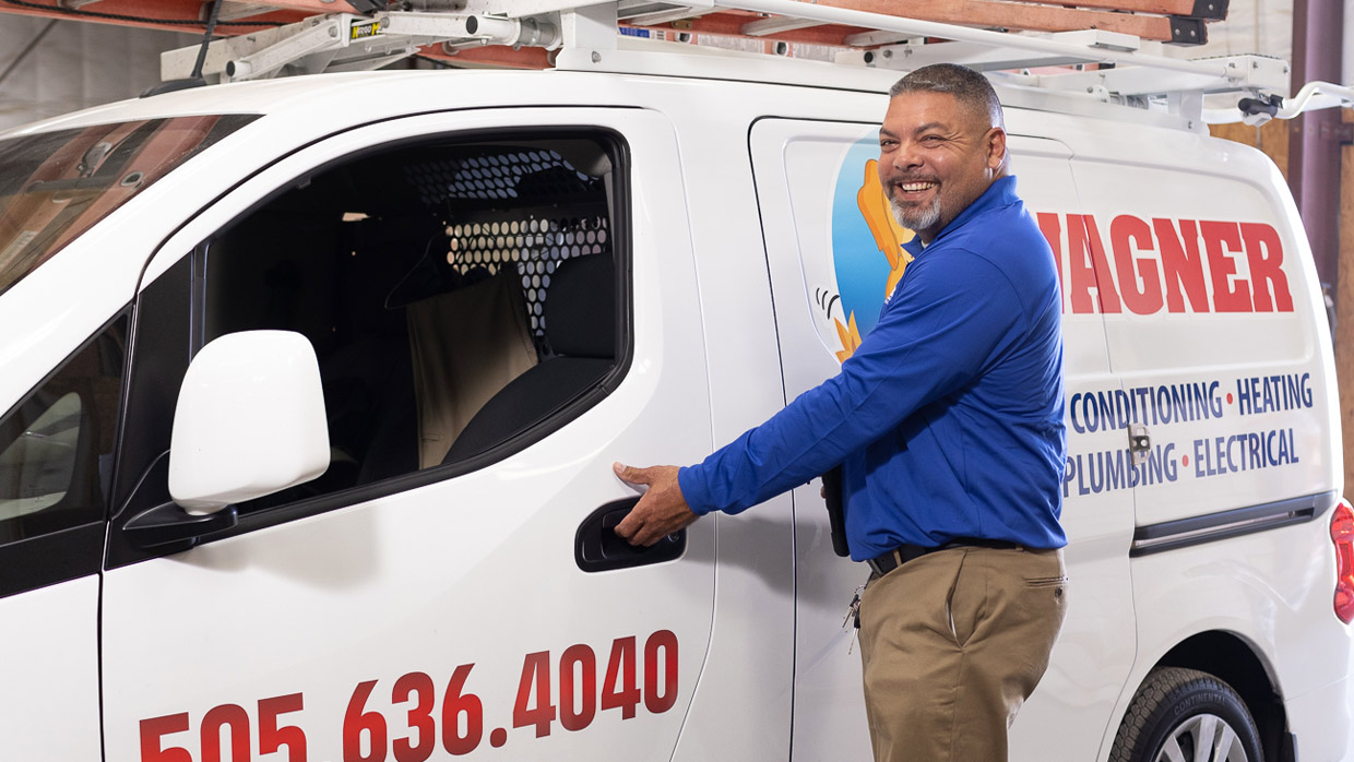 Smiling man opening Wagner van door, Albuquerque.