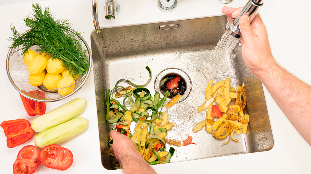 Food scraps in sink under running water