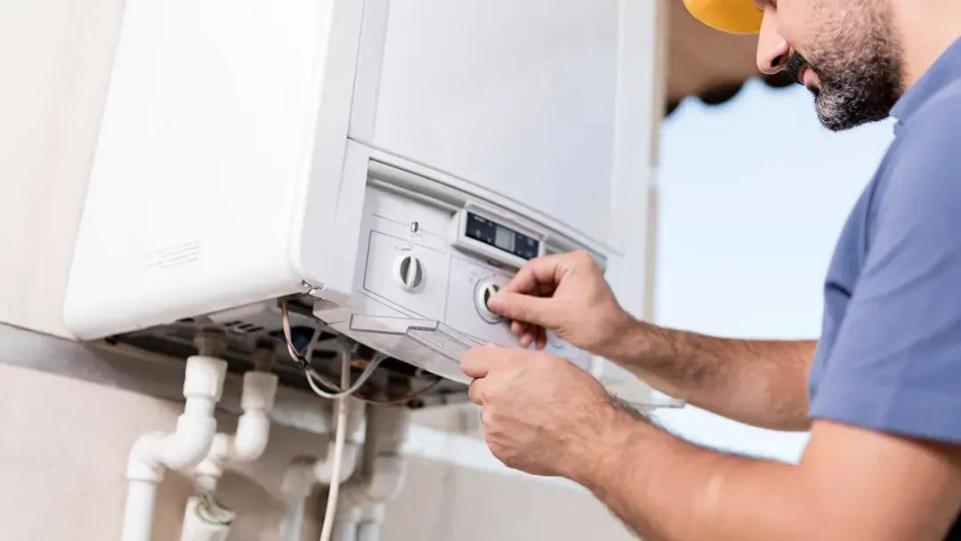 A technician adjusts an on-demand water heater.