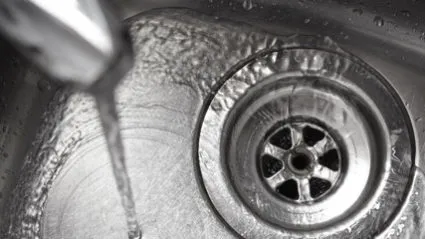 Running water in metal sink drain
