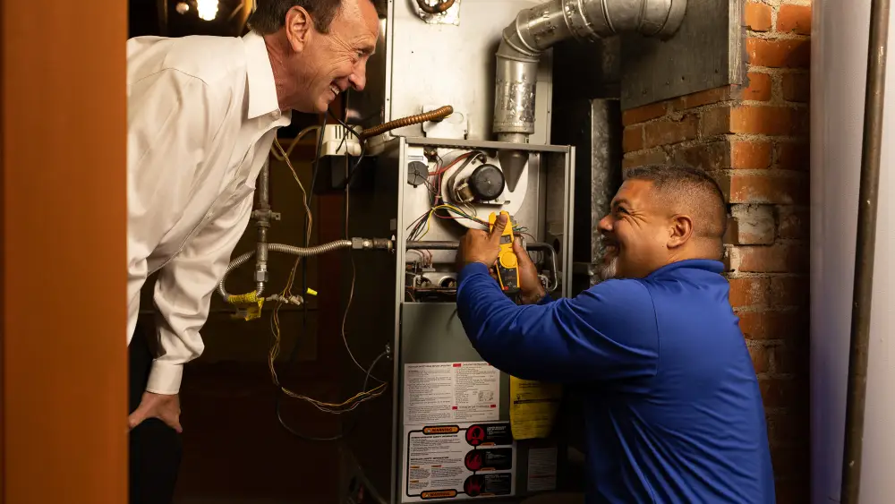 Two technicians working on a furnace.