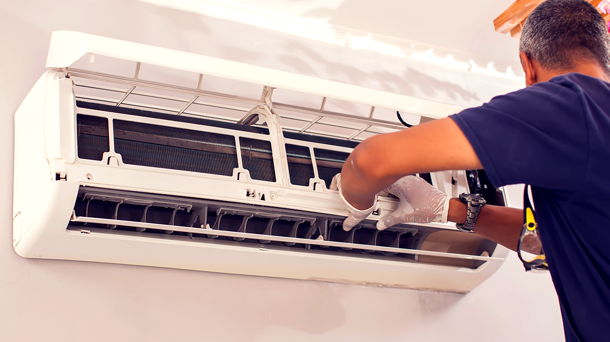 Technician inspecting wall-mounted air conditioner.