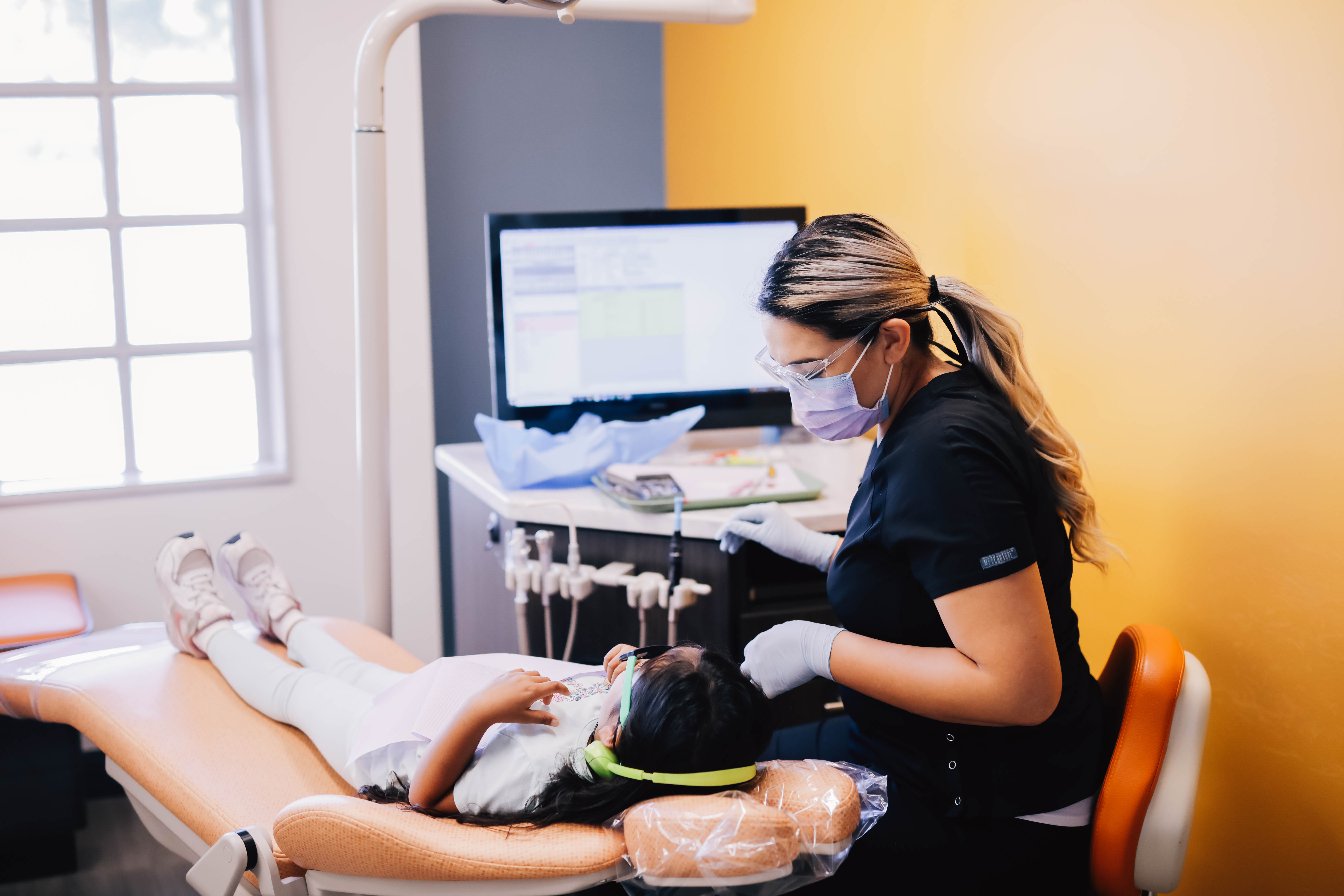 Team member caring for a young patient at Encinitas Pediatric Dentistry & Orthodontics in Encinitas, CA
