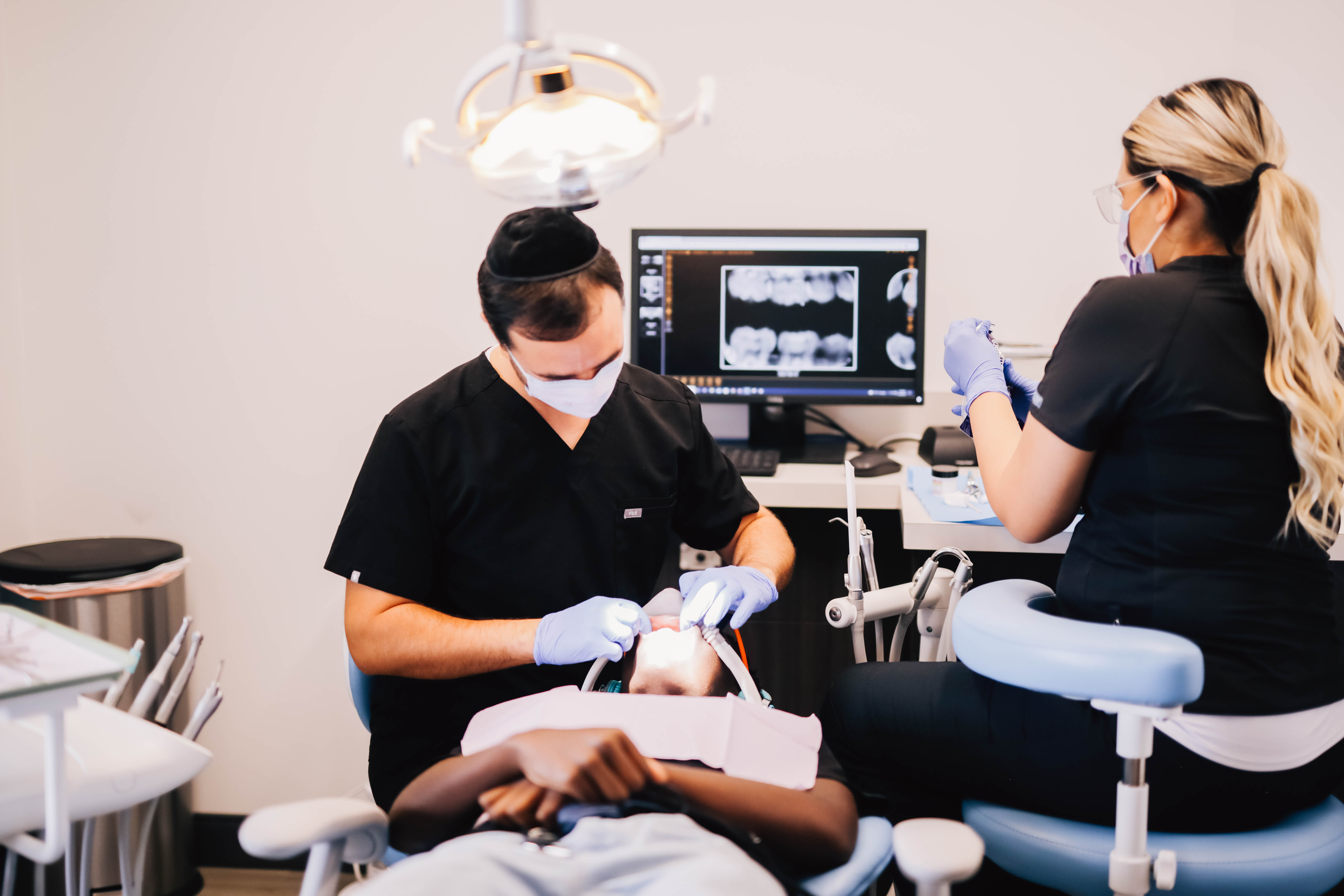 Pediatric dentist and assistant examining a child at Encinitas Pediatric Dentistry & Orthodontics in Encinitas, CA