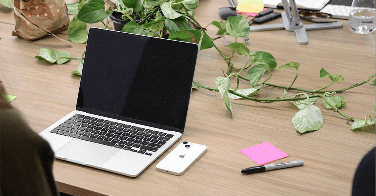 Modern workspace with a laptop, phone, and notes, reflecting on the process of developing AI software with real-time voice.