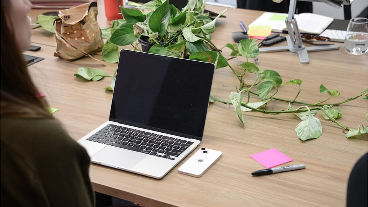 Modern workspace with a laptop, phone, and notes, reflecting on the process of developing AI software with real-time voice.