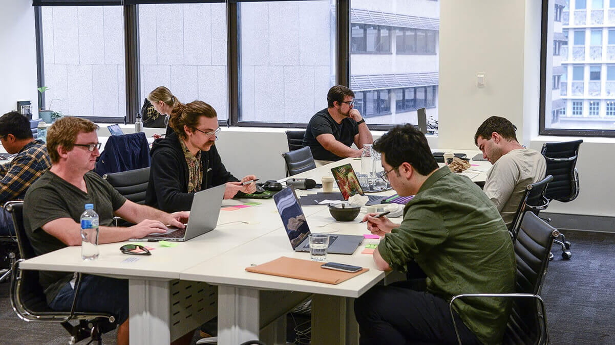 Airteam's team members sitting at a co-working space in Sydney.