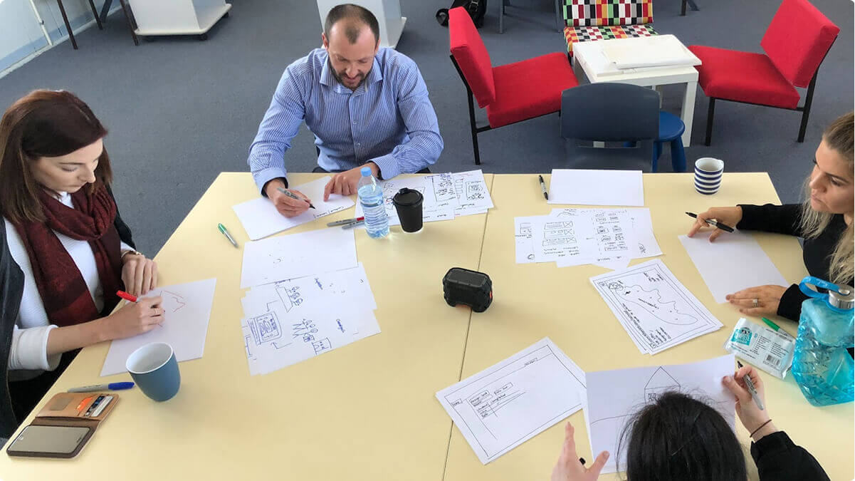 Airteam team members sitting at a desk working on a development project together.