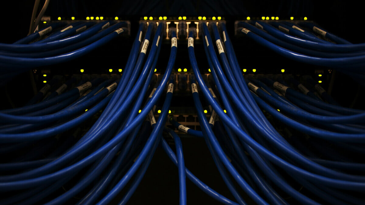 Blue network cables connected to server racks in a dark data centre, illustrating Airteam research into Australians’ concerns