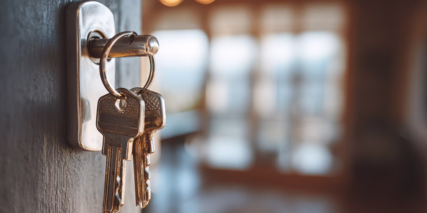 Bild eines Schlüssels im Schloss einer Tür, warmes Ambiente innerhalb einer Wohnung/Haus