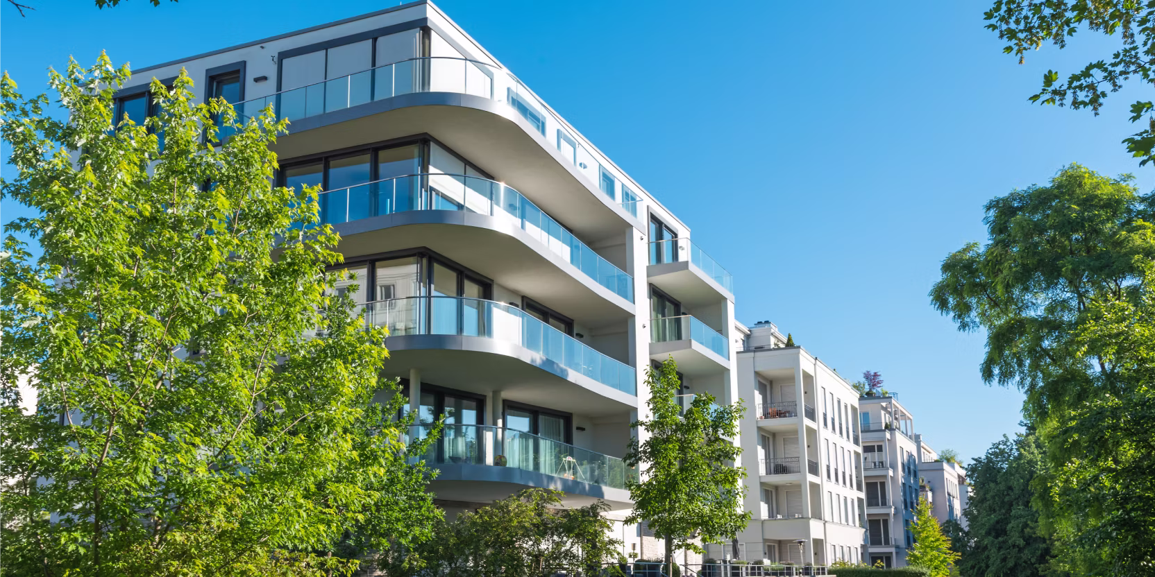 Bild einer 5-stöckigen Neubausiedlung im Grünen