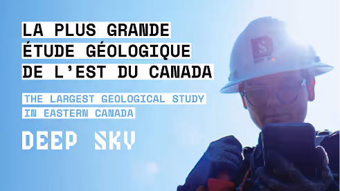 Person wearing a hard hat and glasses holding a device against a bright blue sky with text about the largest geological study in Eastern Canada.