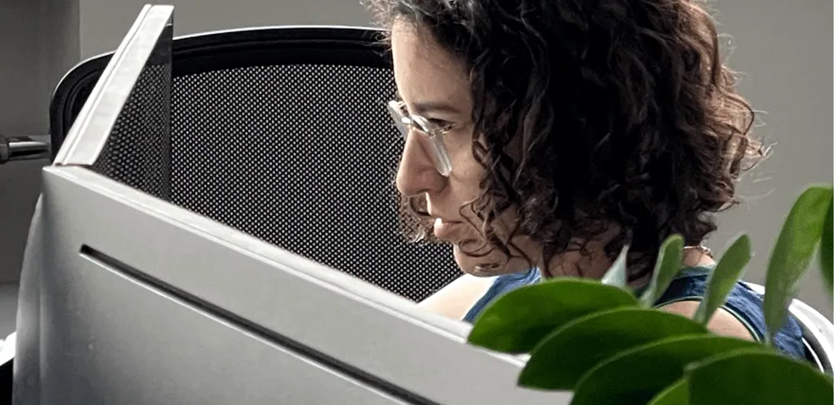 a woman with glasses works in front of a computer