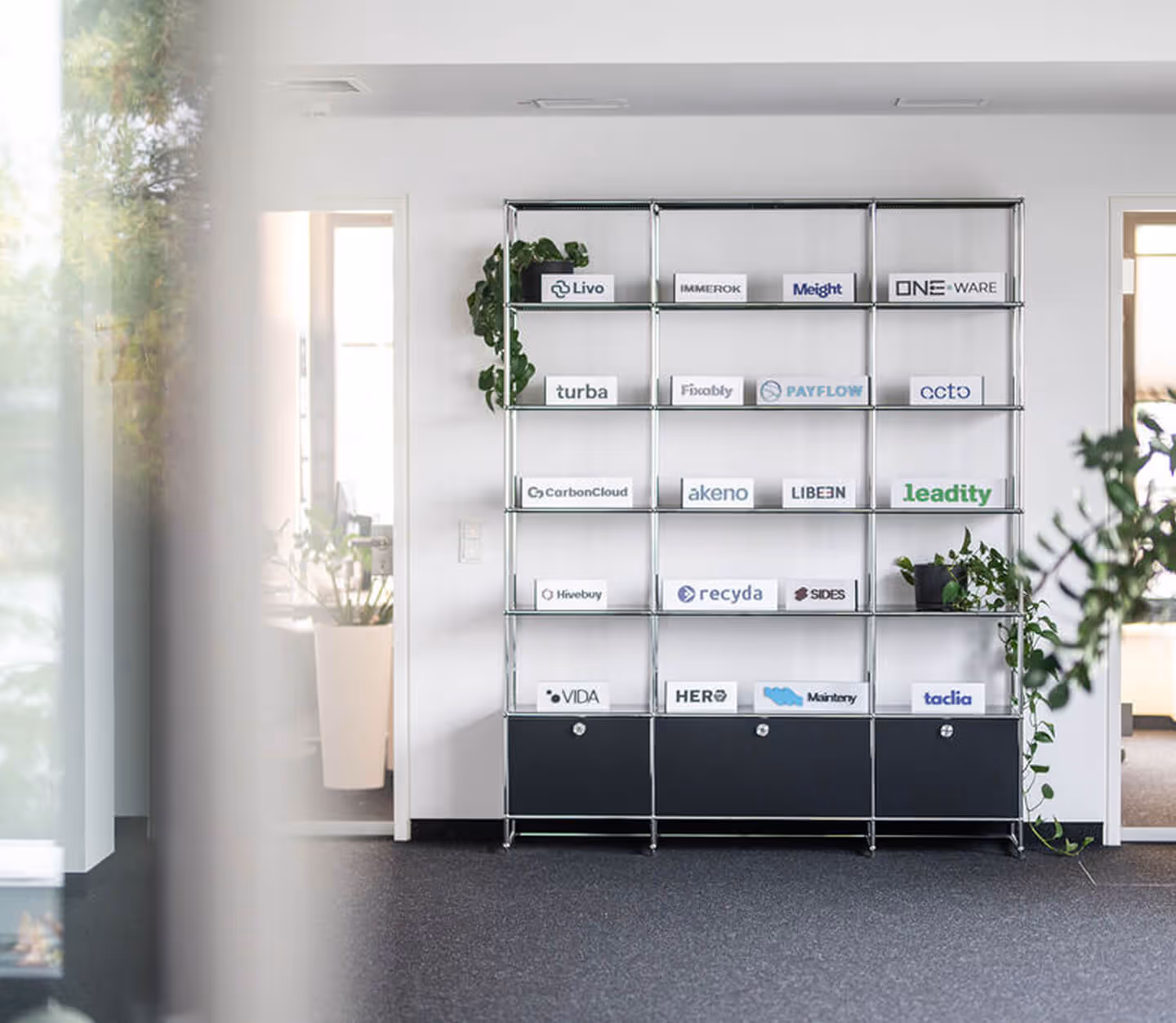 Regal im Büro von Cusp Capital mit Logo Aufstellern von allen Portfolio unternehmen