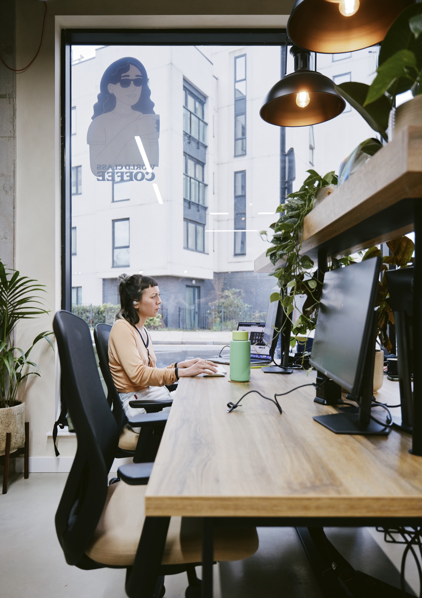 Plug-and-play hot desks with monitors by the window at Drop-in Clapton