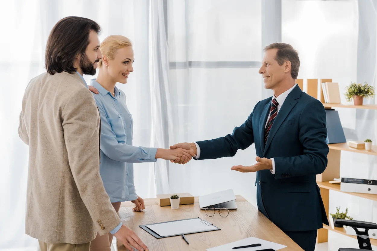 a man and a woman shaking hands with a professional in a suit