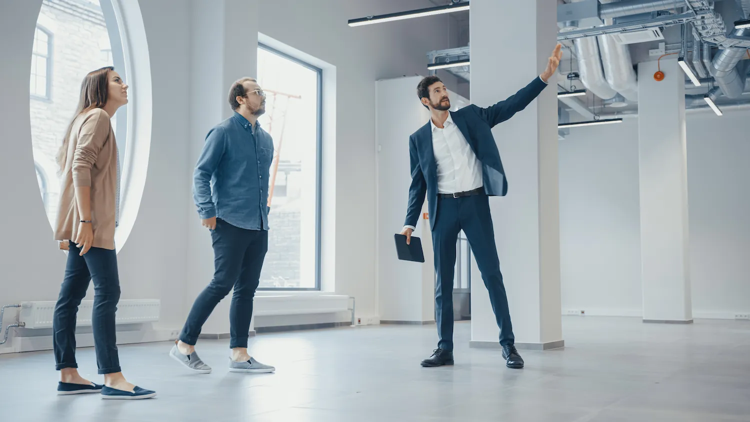 three people meet with the broker with a tablet and discuss the service they wish to purchase or lease