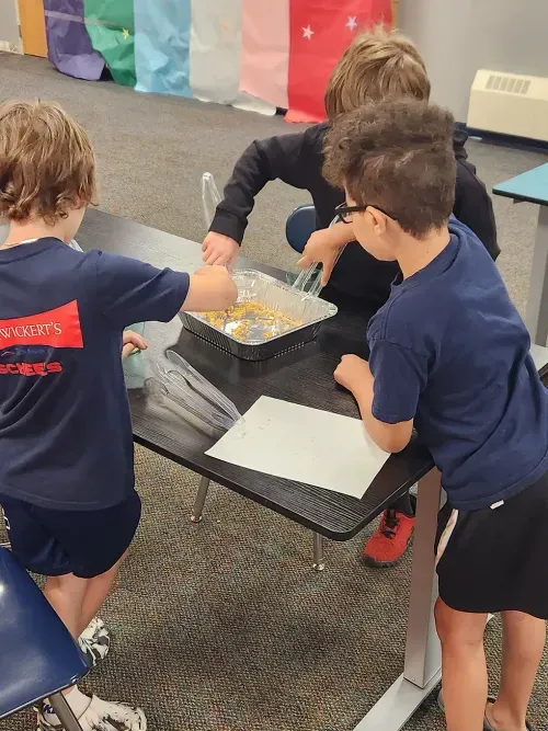 students using tongs to pick up things
