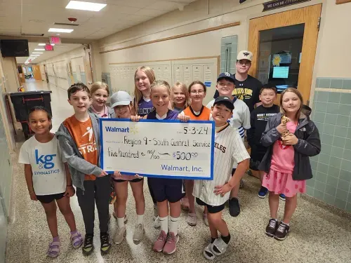 students holding a big check