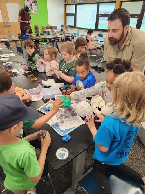 adults helping students build with styrofoam