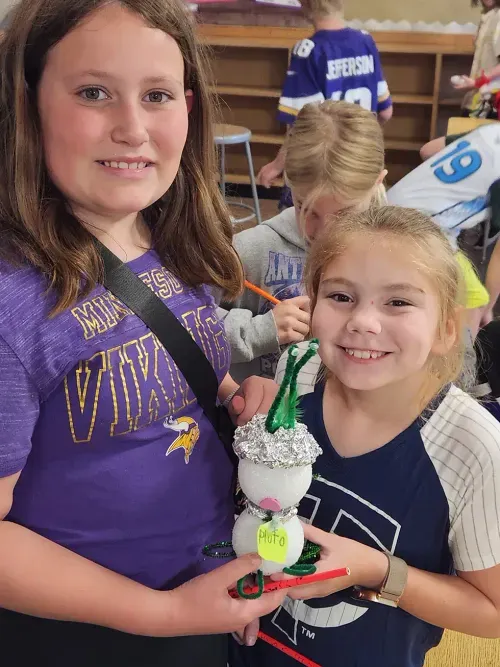 two girls posing with their final project