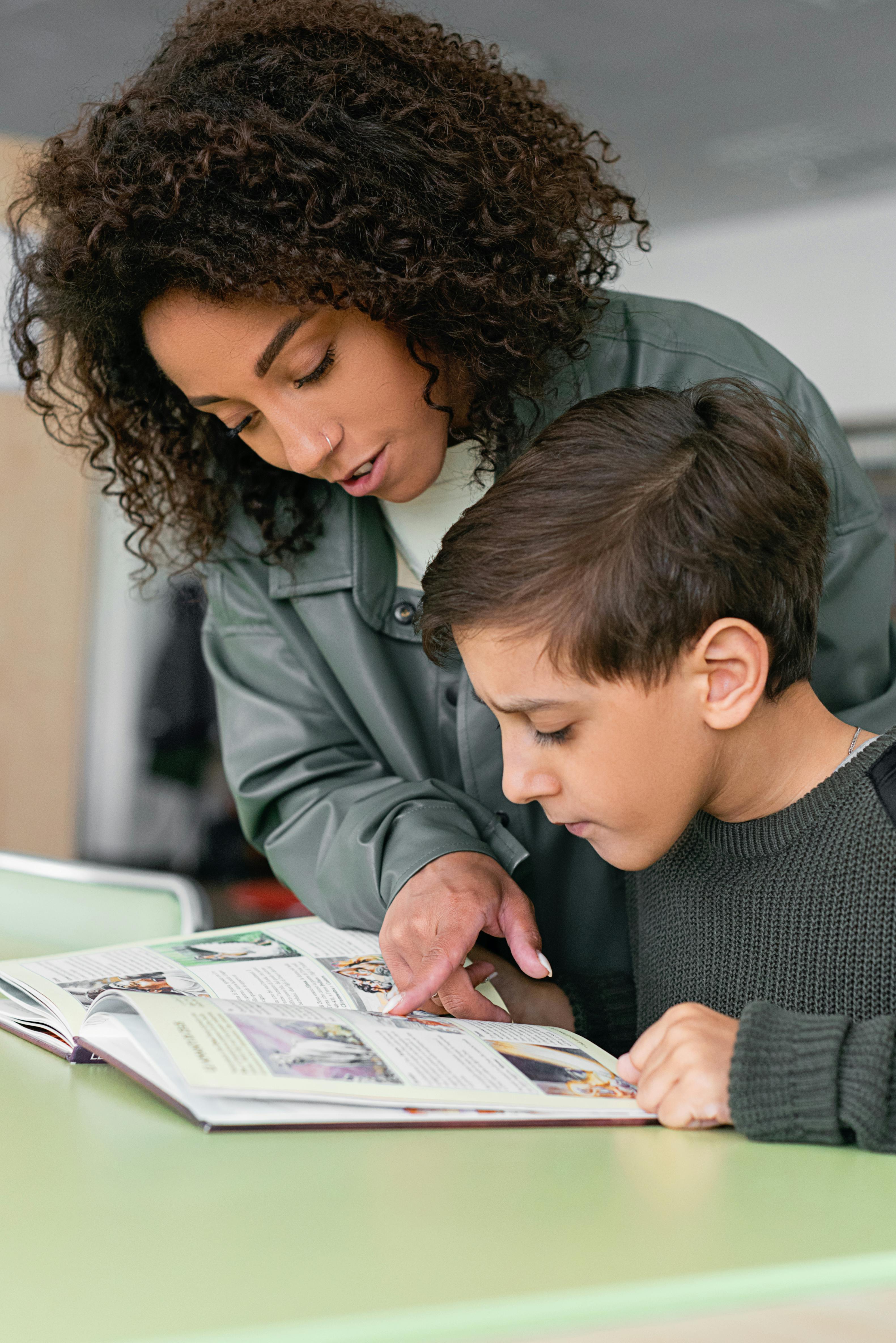 Teacher helping a student learn to read