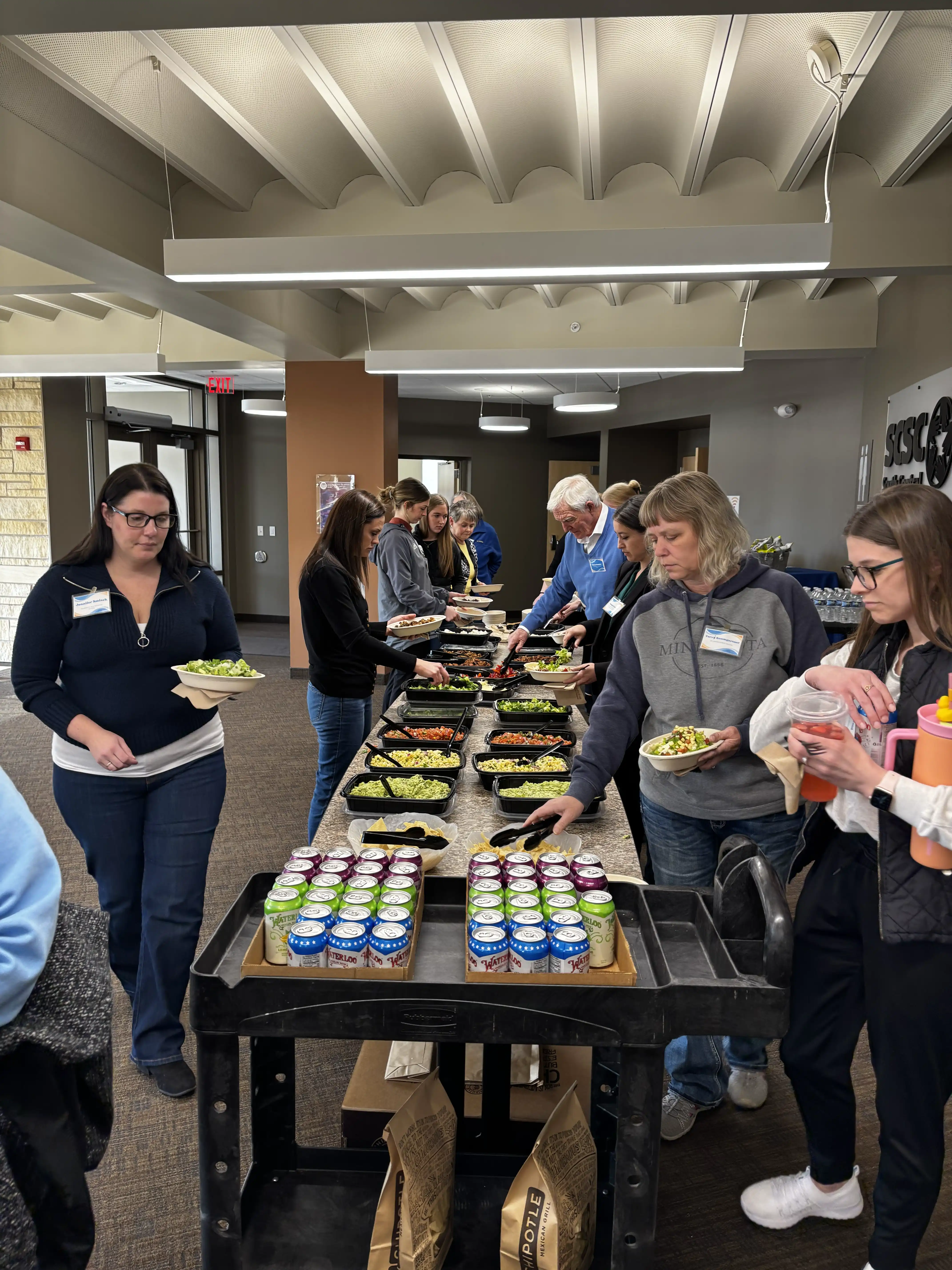 Conference attendees getting in food line by a table